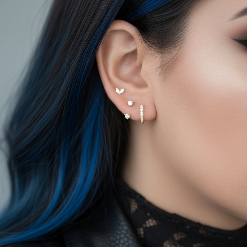 Close-up of an ear wearing multiple gold and diamond earrings.