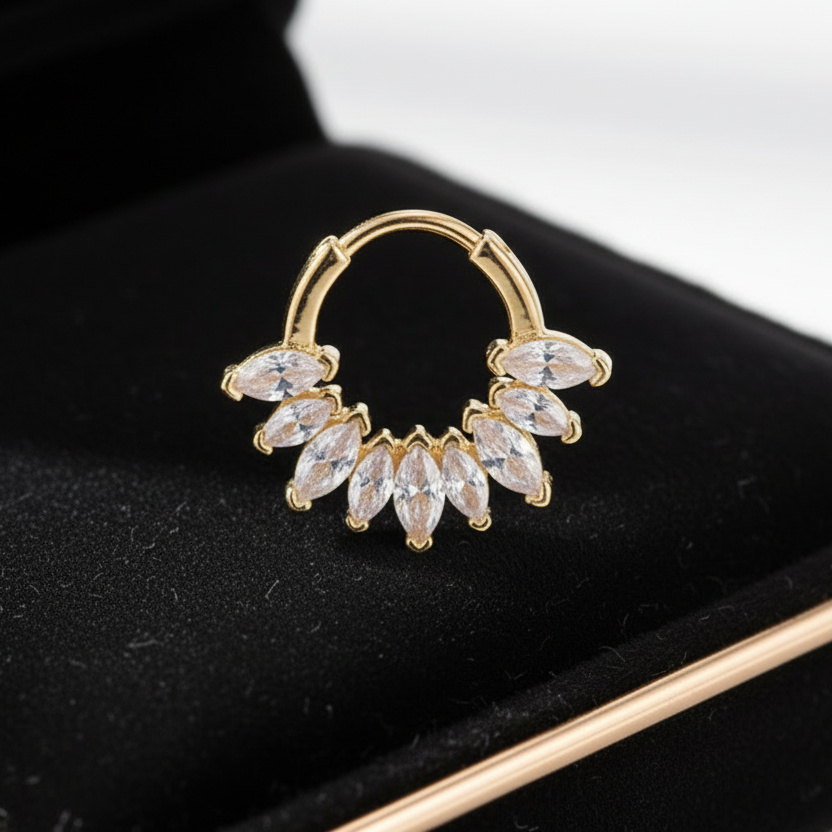 Gold earring with clear stones on a blue velvet surface