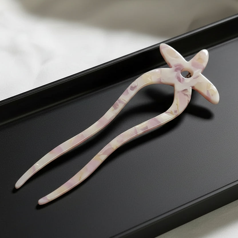 Decorative hairpin with floral design on a white fabric background