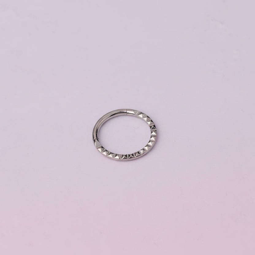 Silver ring on a light purple background