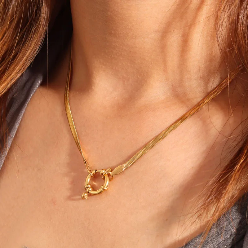 Gold necklace with a clasp on a person's neck